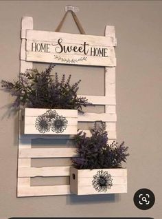 some plants are hanging on a wall with the words home sweet home written above them