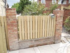 a wooden fence is in front of a brick building