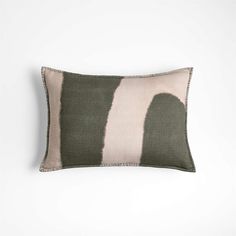 a green and white striped pillow on a white wall with a black stripe in the middle