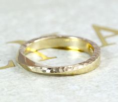 two gold wedding bands sitting on top of each other