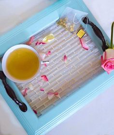 a cup of tea and some flowers on a tray