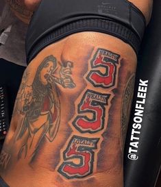 the back of a man's leg with tattoos on it and numbers in different colors