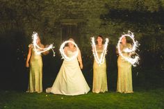 the bride and her four bridesmaids hold sparklers spelling love in front of them