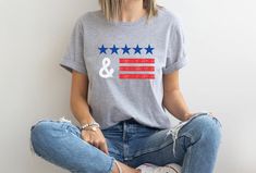 a woman sitting on the floor wearing an american mama t - shirt