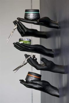 several black gloves are hanging on the wall with scissors and other items in them,