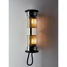 a wall mounted light with two lights on it's sides and a cord attached to the side