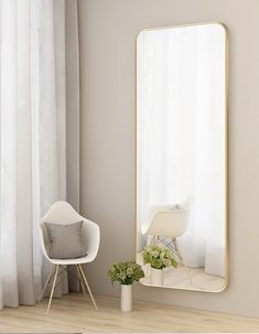 a white chair sitting in front of a large mirror on the side of a wall