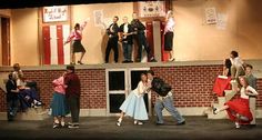 a group of people standing on top of a brick wall next to each other in front of a crowd