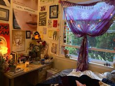 a bedroom with purple curtains and pictures all over the wall, along with a bed