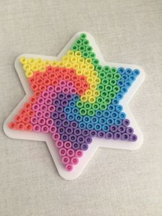 an ornament made out of plastic beads with a star on the front and bottom