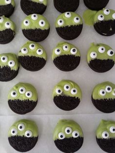 green and black cupcakes with googly eyes on them are arranged in rows