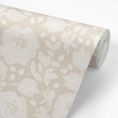 a beige floral wallpaper with white leaves and flowers on the back half of it