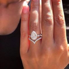 a close up of a person's hand with a diamond ring on her finger