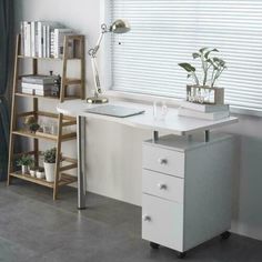 a white desk with two drawers and a laptop on it, next to a window