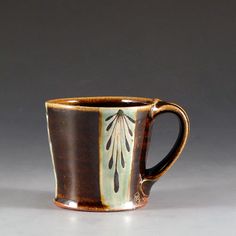 a brown and white coffee cup sitting on top of a table