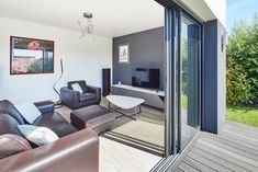 a living room filled with furniture next to a sliding glass door leading to a patio