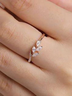 a woman's hand with a diamond ring on top of her finger and the other hand holding it