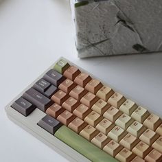 a computer keyboard sitting on top of a white table next to a block of cement