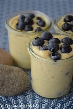 three small jars filled with blueberries on top of a table