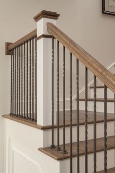 a staircase with wooden handrails and metal balustncing in a home