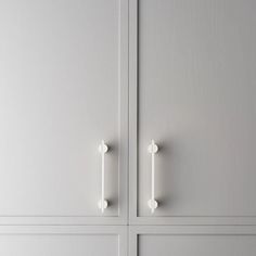 two white cupboards with handles and knobs on them