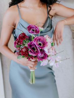 a woman holding a bouquet of flowers in her hands