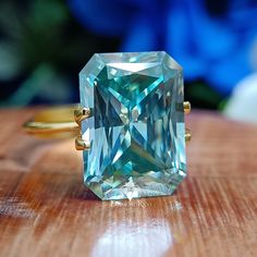 Big Radiant Colored Moissanite Engagement Ring, 20 CT Blueish Green Moissanite Solitaire Bridal Wedding Ring, Huge Women Promise Ring, Gifts for Her, Anniversary Ring, Birthday Sale, Solid Gold Moissanite Diamond Jewelry, Dainty Cocktail Ring ✶ 𝐒𝐭𝐨𝐧𝐞 𝐒𝐢𝐳𝐞 (𝐀𝐩𝐩𝐫𝐨𝐱.) - 20 CT = 18x14 mm - 15 CT = 16x12 mm - 10 CT = 14x11 mm ✶ 𝐏𝐫𝐨𝐝𝐮𝐜𝐭 𝐈𝐧𝐟𝐨𝐫𝐦𝐚𝐭𝐢𝐨𝐧 ➙ Stone Type: Moissanite ➙ Stone Shape: Radiant Cut ➙ Stone Color: Blue-Green ➙ Stone Clarity: VVS ➙ Stone Make: High Qual Radiant Moissanite Engagement Ring, Colored Moissanite, Radiant Engagement, Radiant Moissanite, Green Moissanite, Blueish Green, Birthday Sale, Radiant Engagement Rings, Colored Engagement Rings