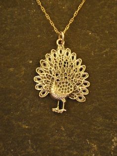 This Peacock Bird pendant is 14K Gold. The included chain is a 14K Gold chain. You may choose 16, 18 or 20 inch at the same price. Other length available at sightly higher prices. This Peacock Bird pendant measures 1 1/8" tall by 13/16" across. I hand cast all my pieces using the lost wax casting method. Please ask your needs. You may call me with questions, often I am out so please use my machine. 831-476-3176. Satisfaction Guaranteed! I send items USPS First Class unless otherwise directed. I Elegant Yellow Gold Necklace With Peacock Design, Festive 22k Gold Necklace With Peacock Design, Formal Gold Necklace With Peacock Design, Elegant Gold Necklace With Peacock Design, Yellow Gold Jewelry With Peacock Design For Gift, Elegant Peacock Design Necklace For Gift, Elegant Round Necklace With Peacock Design, Silver Filigree Necklace In 14k Gold, Elegant Round Peacock Design Necklace