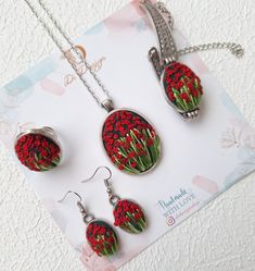 a necklace and earring set with red flowers