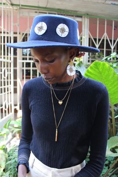 Handmade in Nairobi , Kenya! A beautiful dark blue hat adorned with white and clear gold beaded pendants. Hat comes with matching earrings. Inner Hat head width- 18cm approx. Inner Hat head length- 20cm approx. Inner Hat circumference- 57cm approx. SHIPPING Shipping is done via DHL Express, 3-7 days delivery, Add multiple items to your cart and pay shipping for one item ONLY! Handmade Adjustable Fedora As A Gift, Adjustable Wide Brim Fedora As Gift, Handmade Short Brim Fedora As Gift, Handmade Fedora With Short Brim As Gift, Bohemian Mini Hat With Short Brim For Gift, Bohemian Mini Hat With Short Brim As Gift, Beaded Fedora Sun Hat, Bohemian Fedora With Short Brim As Gift, Handmade Flat Brim Fedora As Gift