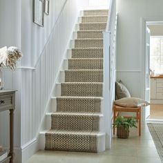 the stairs in this house are lined with jute rugs, and have been painted white