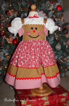 a brown and red dress sitting on top of a box next to a christmas tree