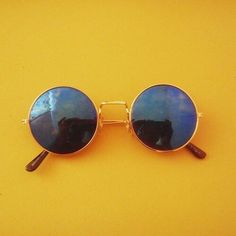 a pair of sunglasses sitting on top of a yellow surface