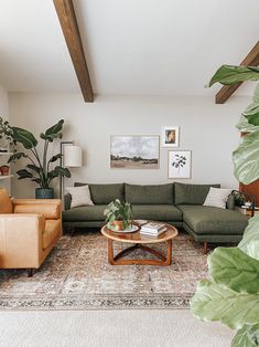 a living room with couches, chairs and pictures on the wall in it's corner