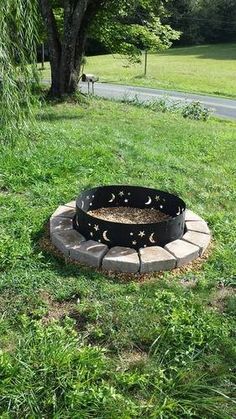 a fire pit sitting in the middle of some grass