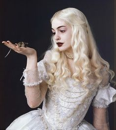 a woman dressed in white holding a flower