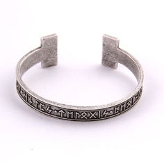 a silver bracelet with greek writing on the side and two small square bars in the middle