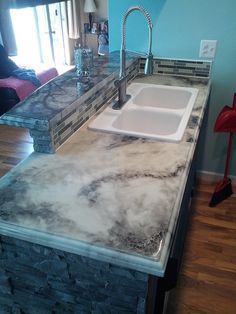 a kitchen counter top with a sink and faucet in the middle of it