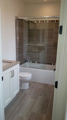 a white toilet sitting next to a bath tub in a bathroom