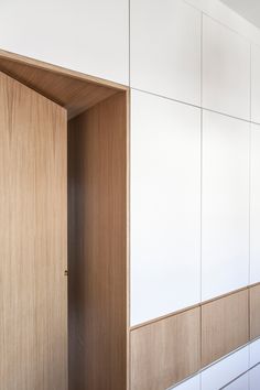 an empty closet with white walls and wooden doors