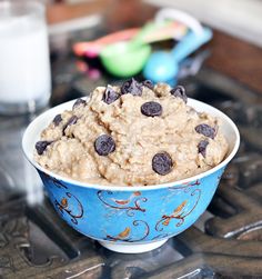 a blue bowl filled with oatmeal and chocolate chips on top of a stove