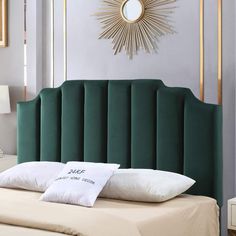 a green headboard with two pillows on it and a gold starburst above the bed