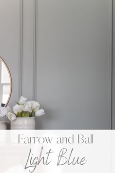 a white vase filled with flowers sitting on top of a table next to a mirror