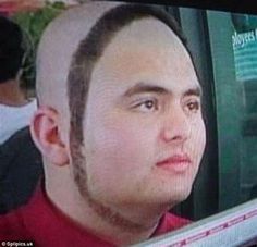 a man with a shaved head is looking at the camera while wearing a red shirt