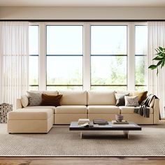 a living room filled with furniture and large windows