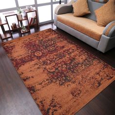 a living room with a couch, chair and rug on the floor in front of a window