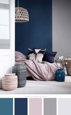 a bedroom with blue walls and white furniture in the corner, along with some baskets on the floor