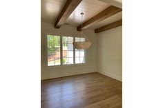 an empty room with wood floors and exposed beams