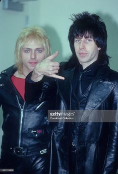 the rockers posing for a photo in their black leather jackets with one finger up