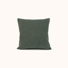 a green pillow sitting on top of a white wall